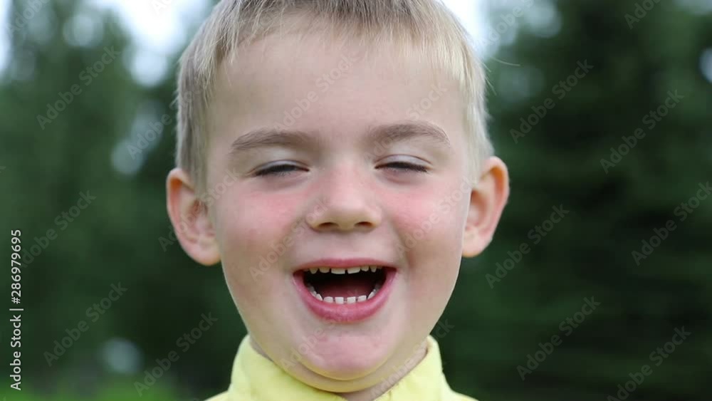 Emotions on face of child. Boy smiles and laughs, close-up Emotions on face of child. Boy smiles and laughs, close-up