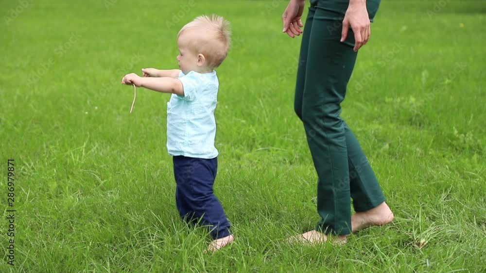 First steps baby boy with help mother. Slow motion First steps baby boy with help mother. Slow motion