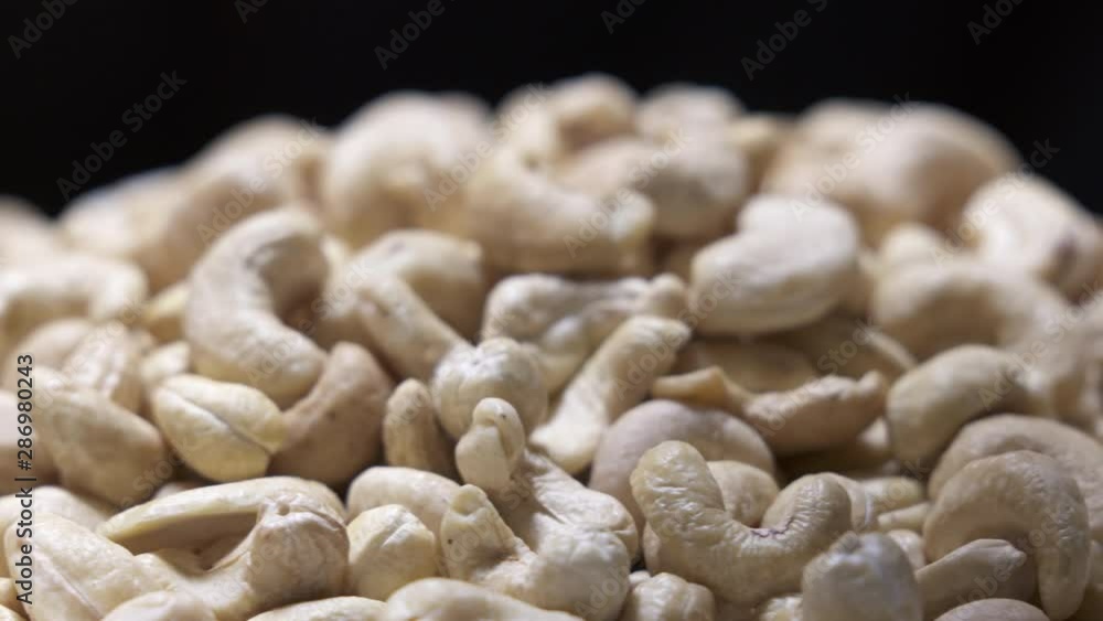 Whole cashew nut background. Pile of raw cashews rotating closeup. Whole cashew nut background. Pile of raw cashews rotating closeup.