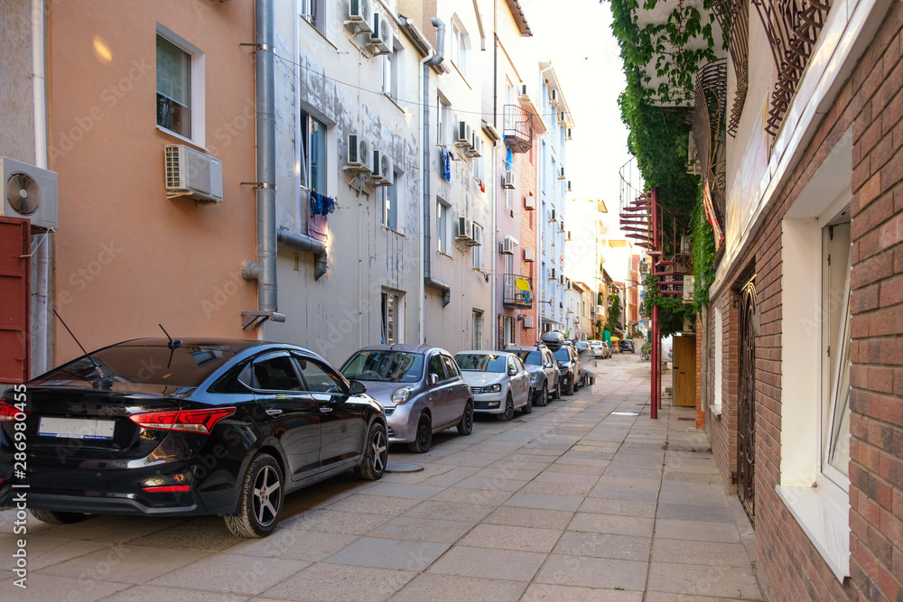 Cars stand along residential buildings in the resort village. Cars stand along residential buildings in the resort village.
