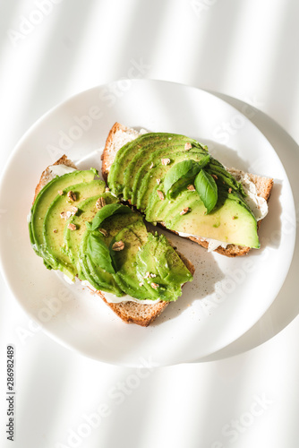 Avocado toasts on a white plate.
