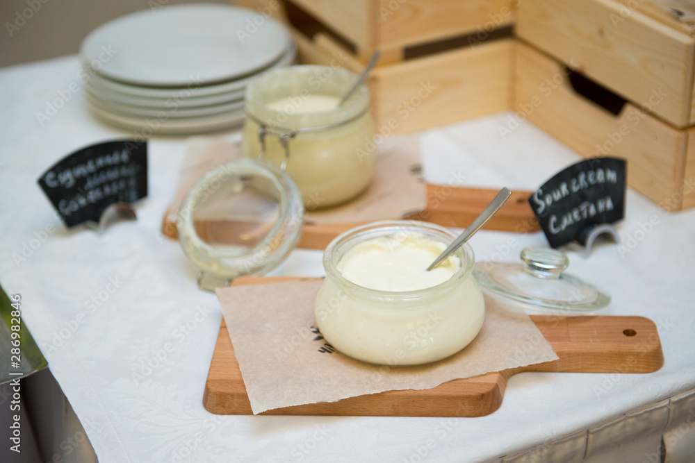 Sour cream in glass jars on a table in a restaurant. Sour cream in glass jars on a table in a restaurant.