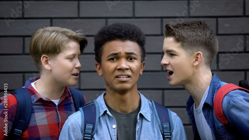 Εκτύπωση καμβά Cruel students teasing black boy face-to-face, telling insults, racial bullying