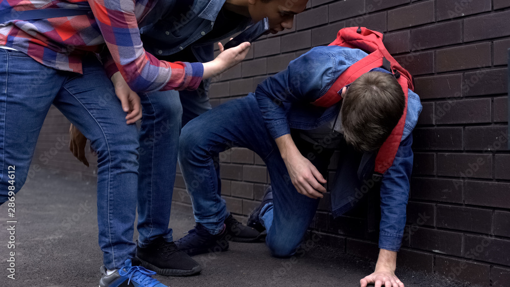 Aggressive teenagers teasing boy and making video on smartphone, cyberbullying Aggressive teenagers teasing boy and making video on smartphone, cyberbullying