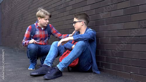 Kind teenage boy starting friendship with bullied student, helpline for children