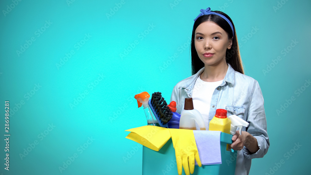 Diligent housewife with basket full of detergent looking at camera, template Diligent housewife with basket full of detergent looking at camera, template