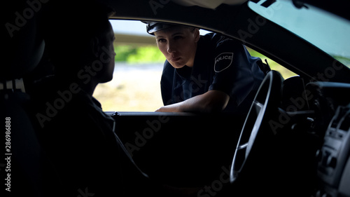 Canvastavla Police woman talking with driver in car, inspection on road, traffic offence