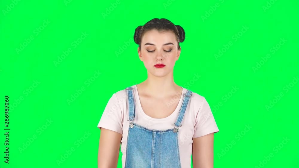 Girl makes selfie on mobile phone using selfie stick on green screen, slow motion Girl makes selfie on mobile phone using selfie stick on green screen, slow motion