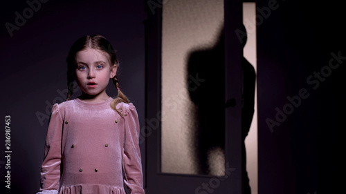 Cuadro en lienzo Scared girl alone in darkness, terrible man creeping behind, childhood fear