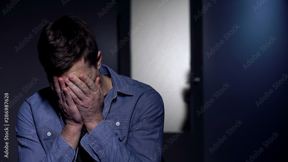 Melancholic male crying in despair, little daughter behind door, depression Melancholic male crying in despair, little daughter behind door, depression