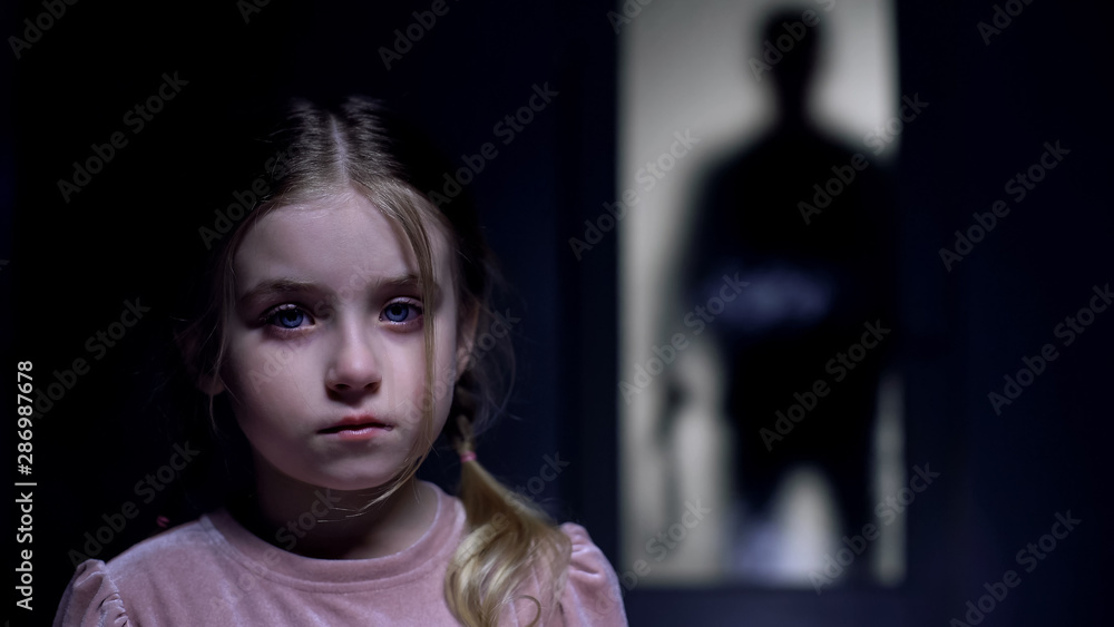 Frightened female kid crying on camera shadow of tyrant father with belt outside Frightened female kid crying on camera shadow of tyrant father with belt outside