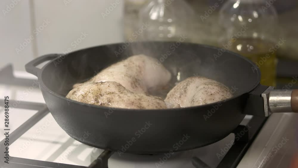Woman making pan fried chicken legs in cast iron frying skillet. Woman making pan fried chicken legs in cast iron frying skillet.