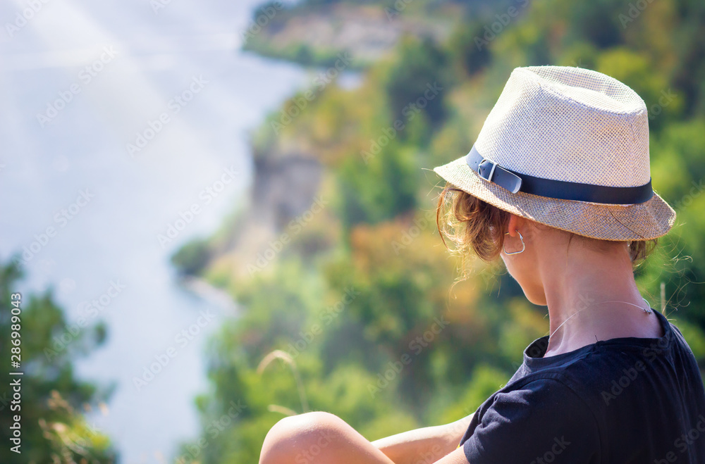 A woman looking to the sea in front of the beautiful ocean sky and island view