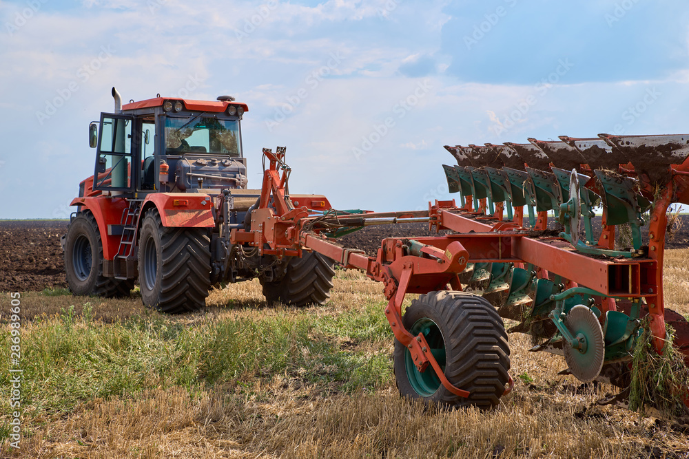 Tractor plows field, cultivators soil for sowing Tractor plows field, cultivators soil for sowing