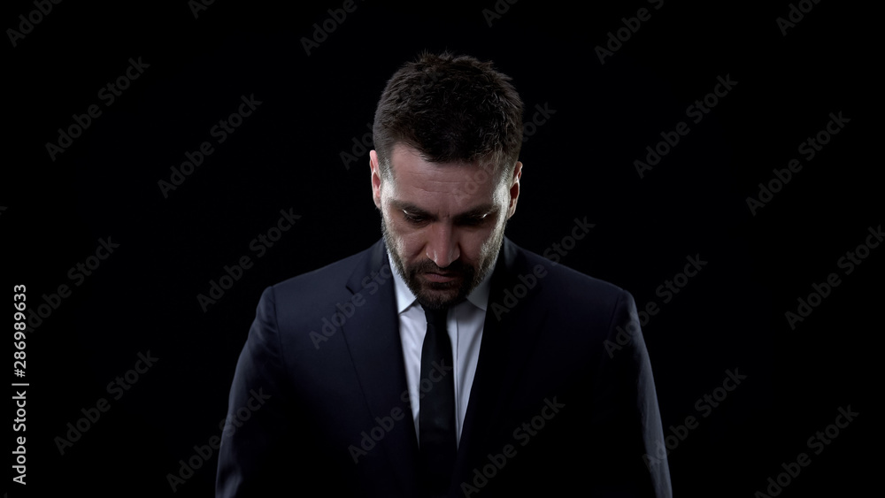 Sad male employee looking down, lack of confidence, life problems, depression Sad male employee looking down, lack of confidence, life problems, depression