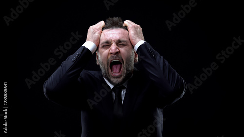Φωτογραφία Worried businessman shouting on dark background, mental exhaustion, pressure