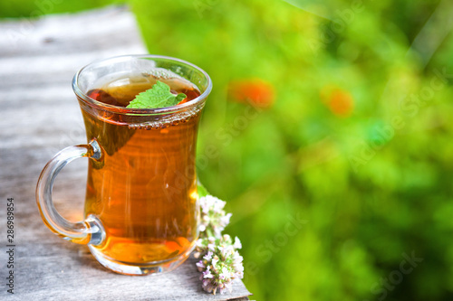 Fresh tasty hot tea with melissa outdoor in summer. Copy space. Medicine healthy