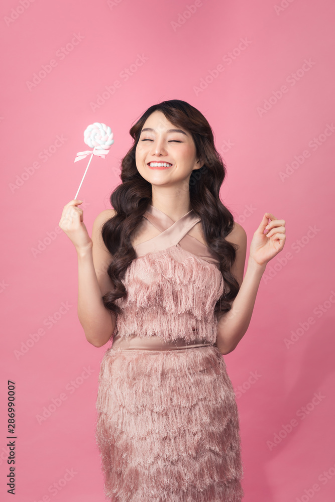 Fashion young woman with sweet makeup holding lolipop in her hands Fashion young woman with sweet makeup holding lolipop in her hands