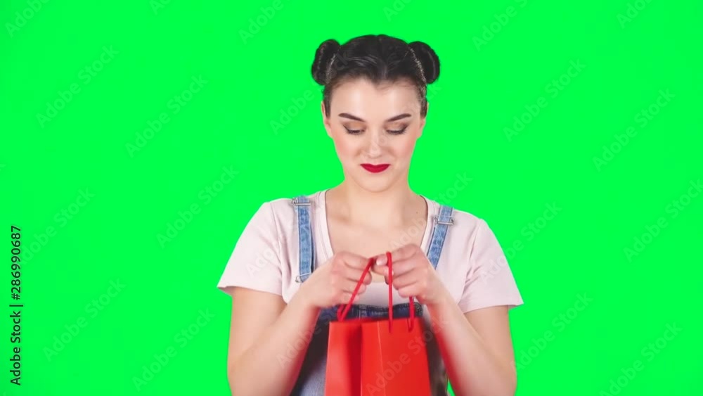 Girl looks in the red package then surprised and very rejoicing hugging him on a green screen, slow motion Girl looks in the red package then surprised and very rejoicing hugging him on a green screen, slow motion