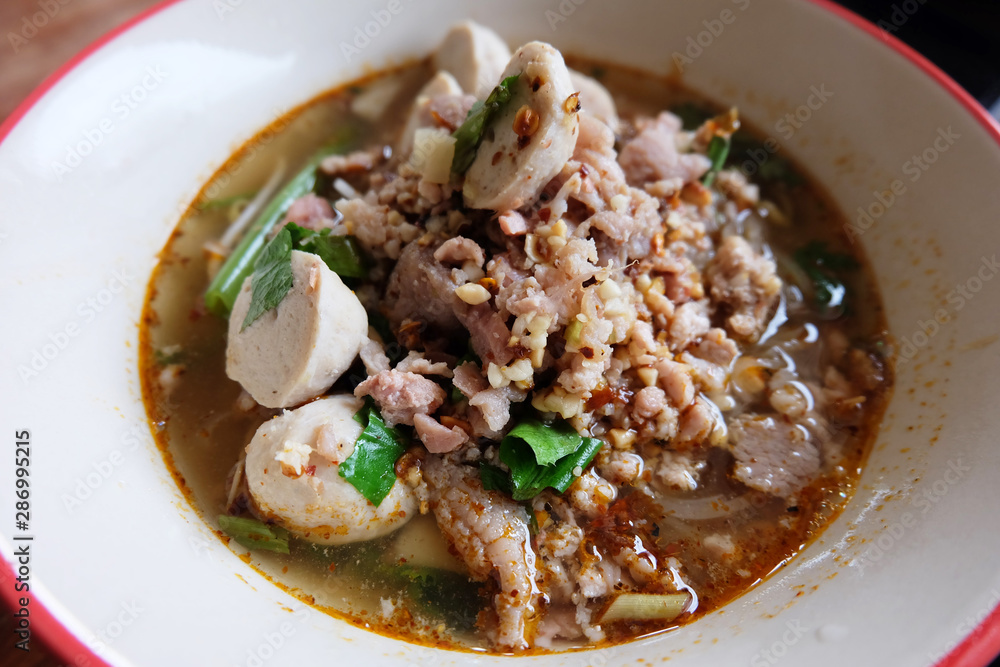 spicy noodle soup with pork or thai name's Tom Yum Pork Noodle on white bowl. spicy noodle soup with pork or thai name's Tom Yum Pork Noodle on white bowl.