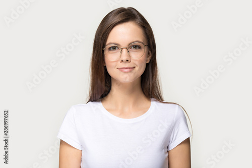 Headshot portrait of millennial girl in glasses posing in studio