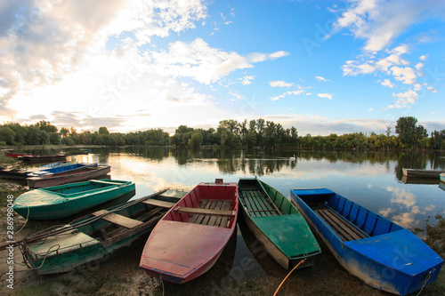 Fototapeta Naklejka Na Ścianę i Meble -  Old rowing boats along the lake shore or river bank in early morning.
