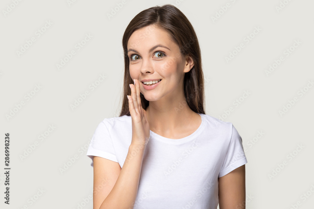 Smiling millennial girl look at camera tell secret information Smiling millennial girl look at camera tell secret information