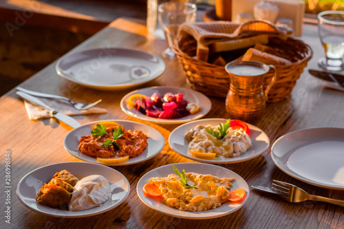 traditional turkish appetizers on table in evening sun light and ayran in a copper glass