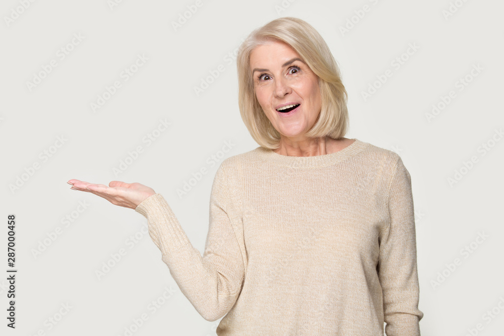 Amazed mature woman show blank copy space with hand Amazed mature woman show blank copy space with hand