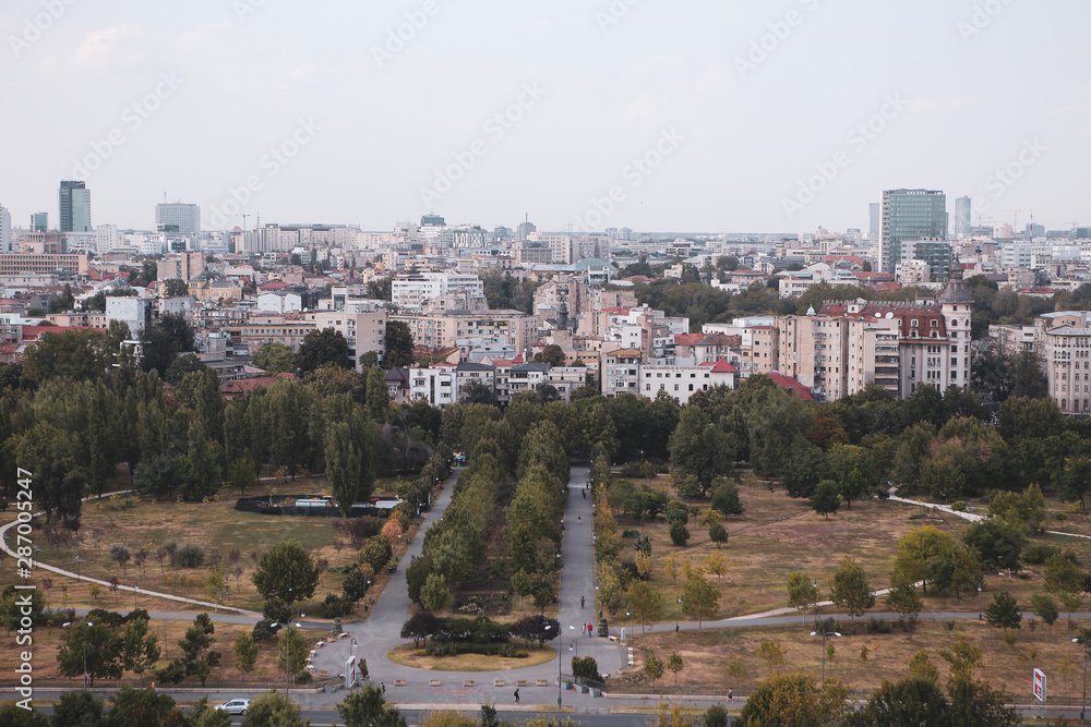 Cityscape of old part of Bucharest, with Izvor Park in the foreground, with many worn out buildings, as seen from the Palace of Parliament