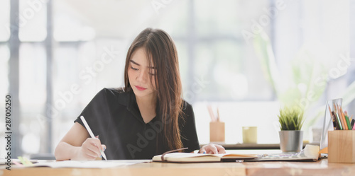 Fotografi Beautiful young designer editing her concept with tablet