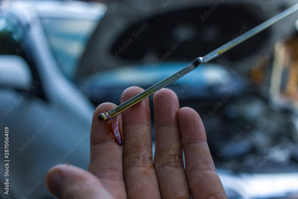 Auto mechanic checking engine oil dipstick in car. Auto mechanic in car repair Auto mechanic checking engine oil dipstick in car. Auto mechanic in car repair