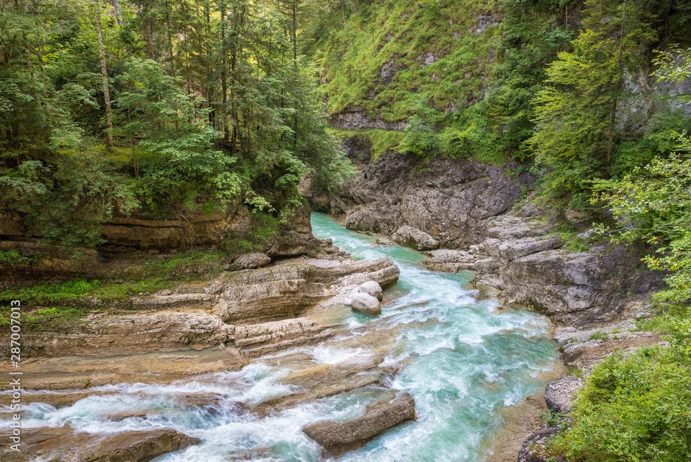 Canyon with wild turquoise to blue colored water stream in the Alps Canyon with wild turquoise to blue colored water stream in the Alps