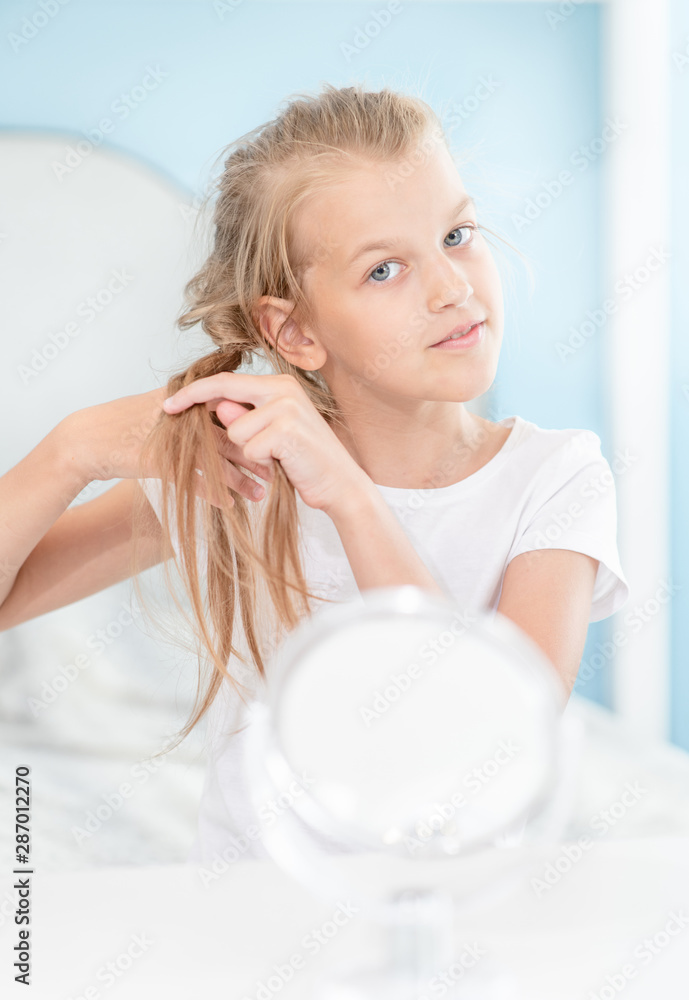 Young girl braids herself in the morning at home Young girl braids herself in the morning at home