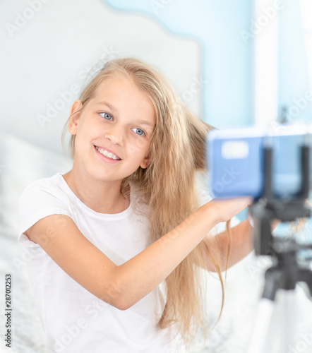 Young beauty blogger filming her beauty blog for her followers. Kids blogger concept