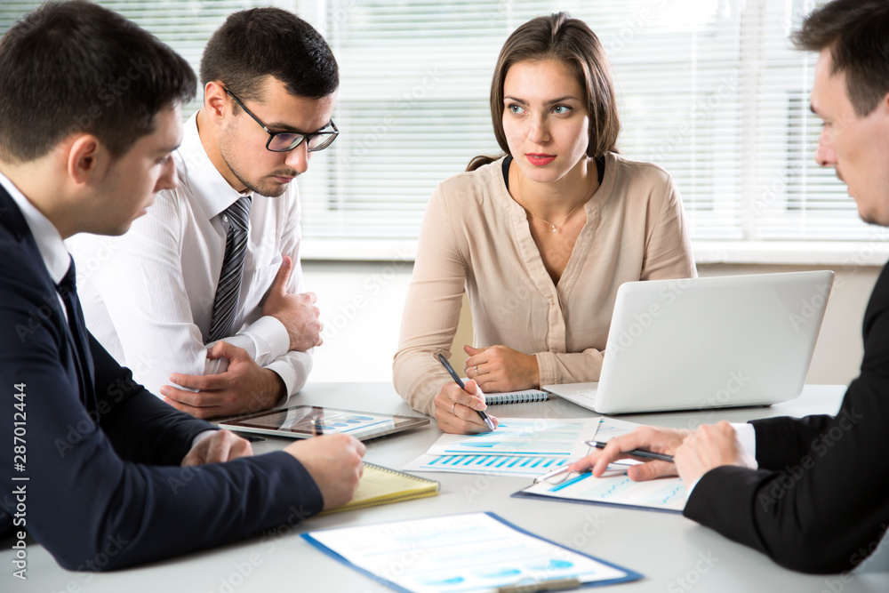 Businesswoman explains to colleagues a new project Businesswoman explains to colleagues a new project