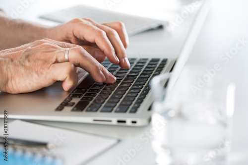 Closeup of businessman's hands working with laptop