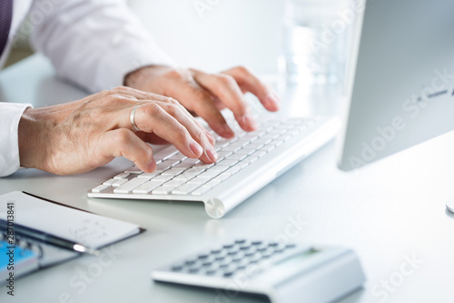 Close-up of businessman hands typing on the keyboard in an office