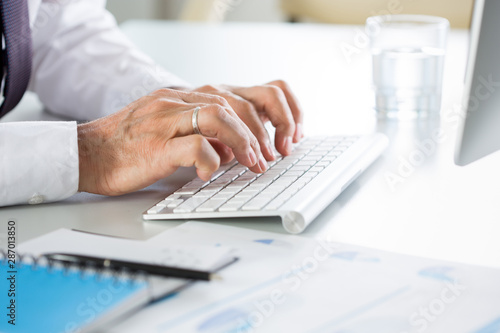 Close-up of businessman hands typing on the keyboard in an office