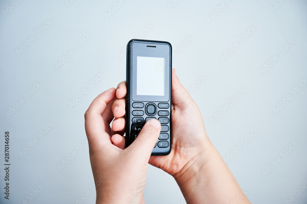 Child holding a traditional mobile phone on white backround Child holding a traditional mobile phone on white backround