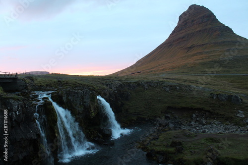 Berghang im Sonnenuntergang mit kleinem Wasserfall davor