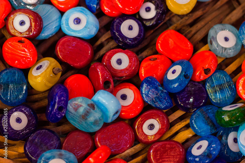 Multicolored nazar - evil eye amulets lie in basket in store on the street