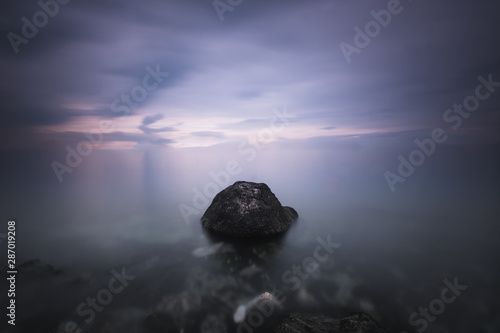 No horizon fine art landscape image. Long exposure of sea with a solid rock image in the middle depicting the loneliness and passage of time. 