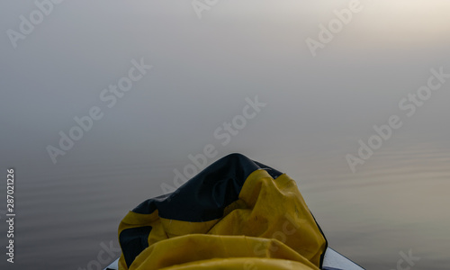a blurred view of a sup board on a blurry lake in the background