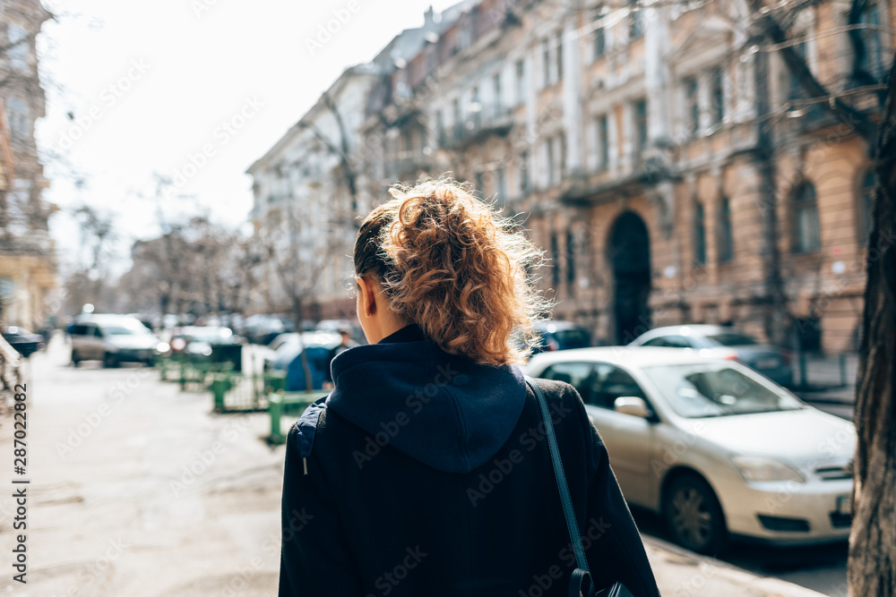 Obraz premium Rear view young woman in black coat