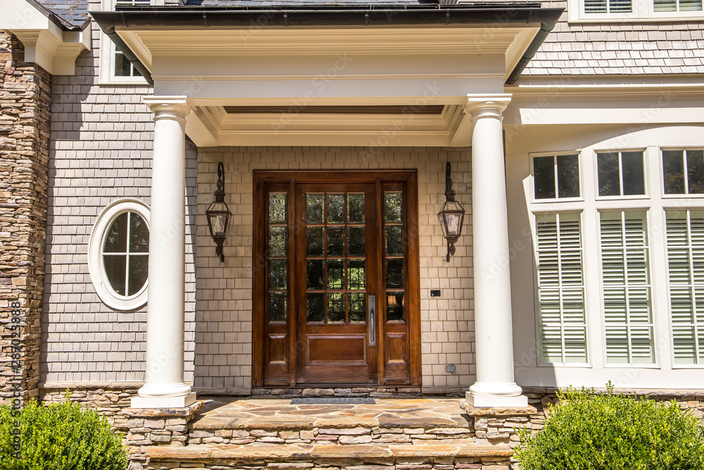 dark wood stained custom door entra nce with windows outside of a large custom home with curb appeal