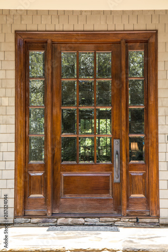 dark wood stained custom door with windows outside of a large custom home