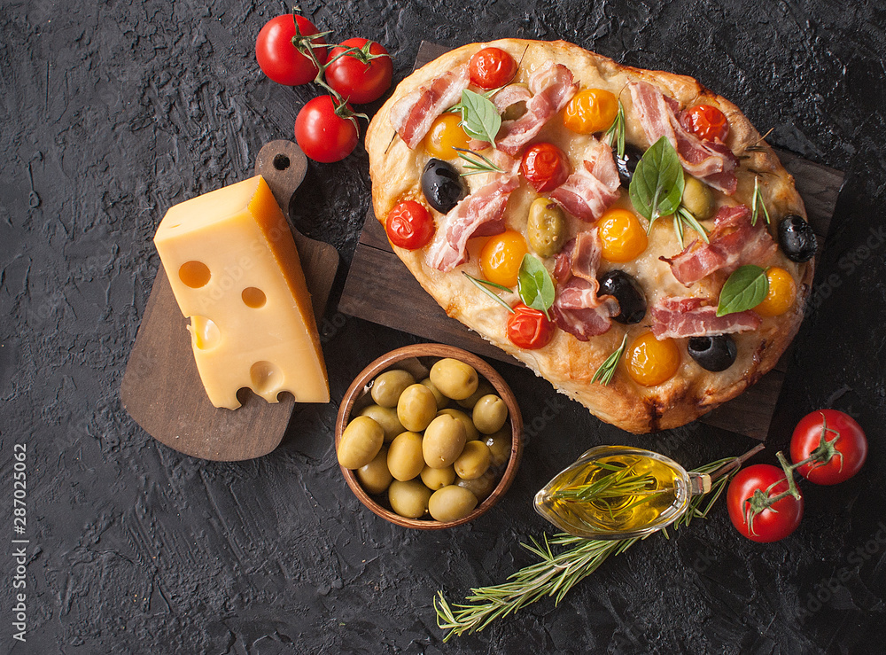 Φωτογραφία Traditional Italian Focaccia with tomatoes, olives, bacon and rosemary - homemade flat bread Focaccia