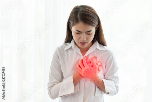 Asian woman having heart attack while hands touching her chest, Healthcare and medical concept