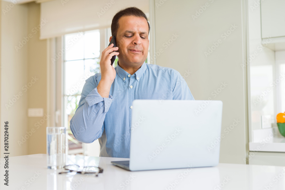 Middle age man working with laptop and using smartphone Middle age man working with laptop and using smartphone